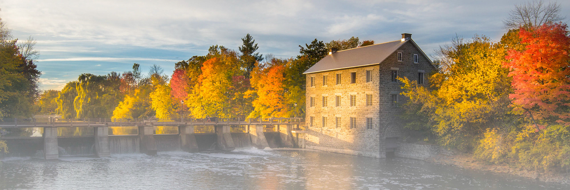 Watson's Mill and the dam on the Rideau River at first light, mist rising off the water
